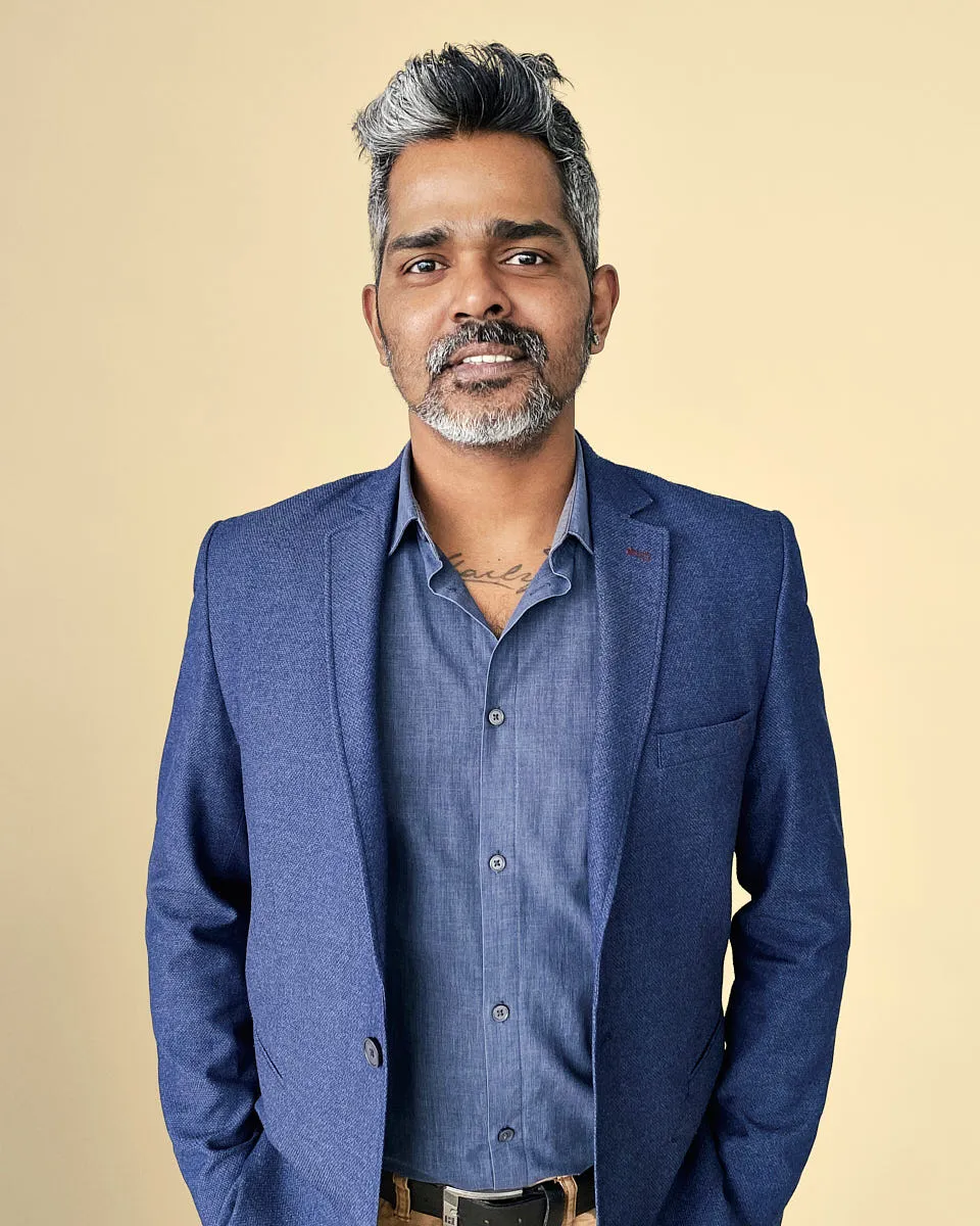 A professional remote headshot of a man in a blue blazer, taken without a studio.