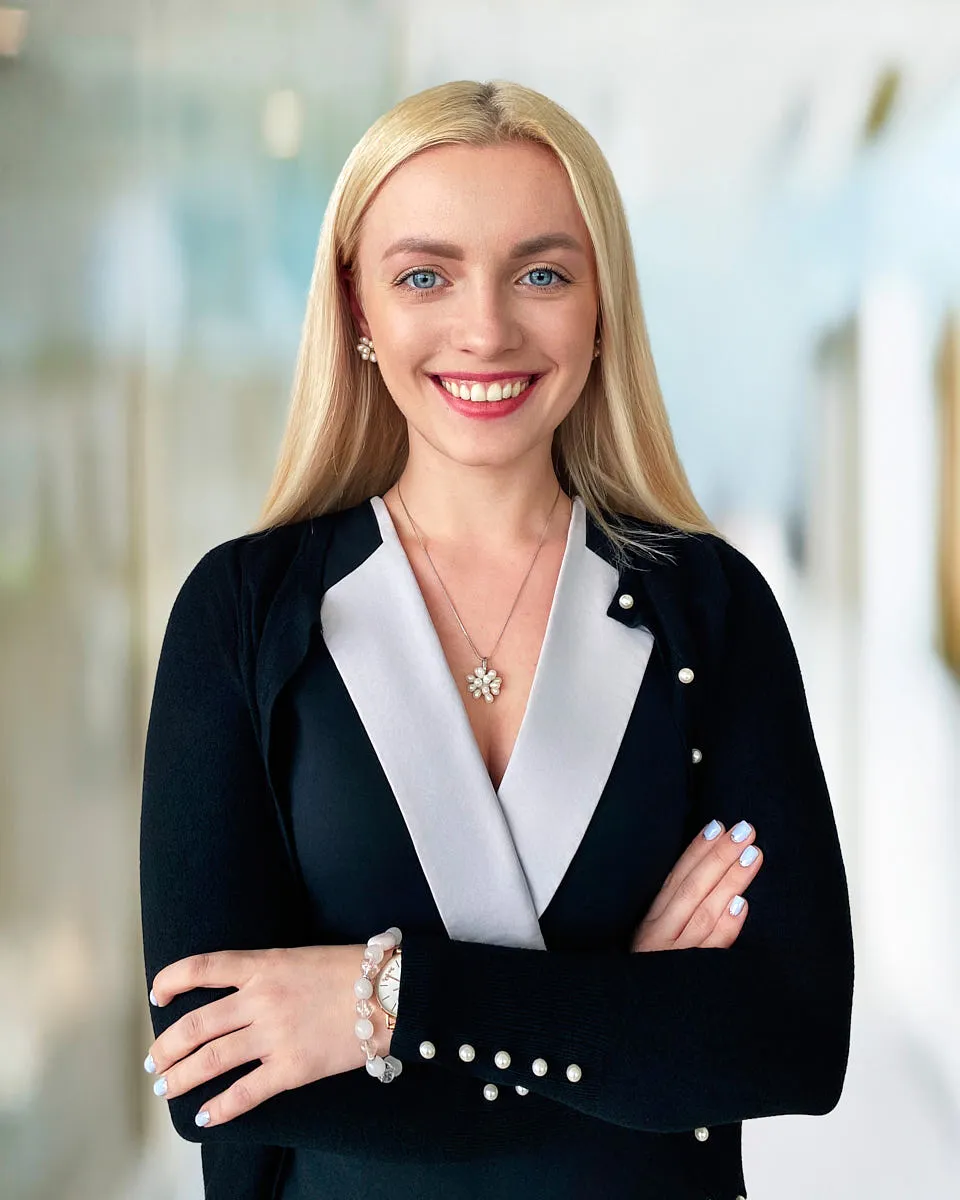 A professional remote headshot of a woman in a business blazer, taken in a live-directed virtual session.