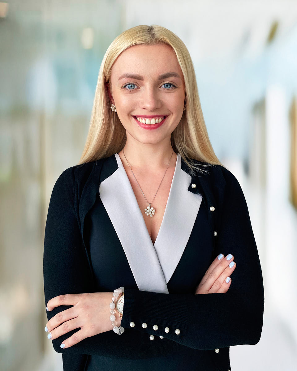 Polished onboarding headshot of a blonde new employee in a business blazer.