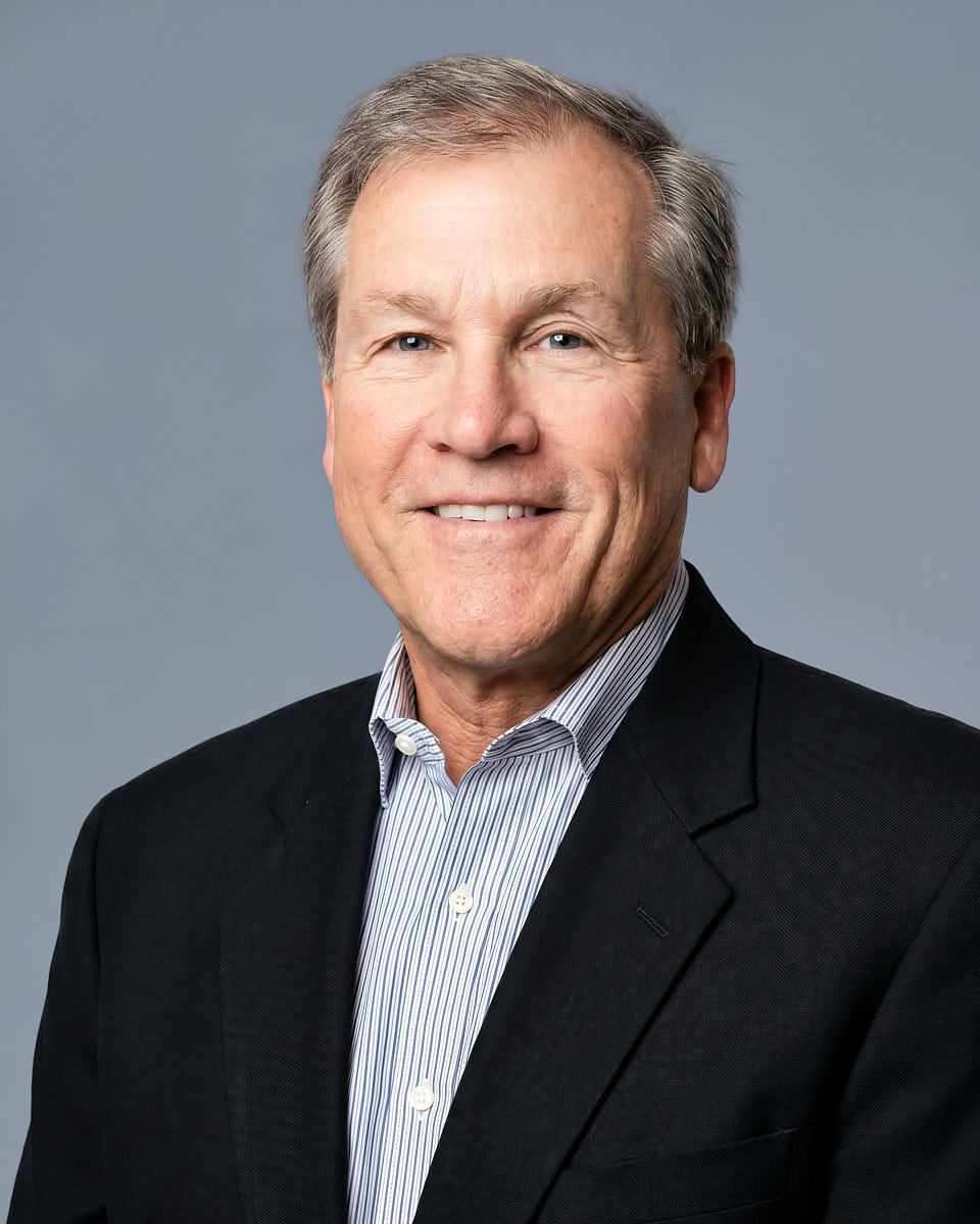 Professional new hire headshot of a man in a dark blazer for company profile use.